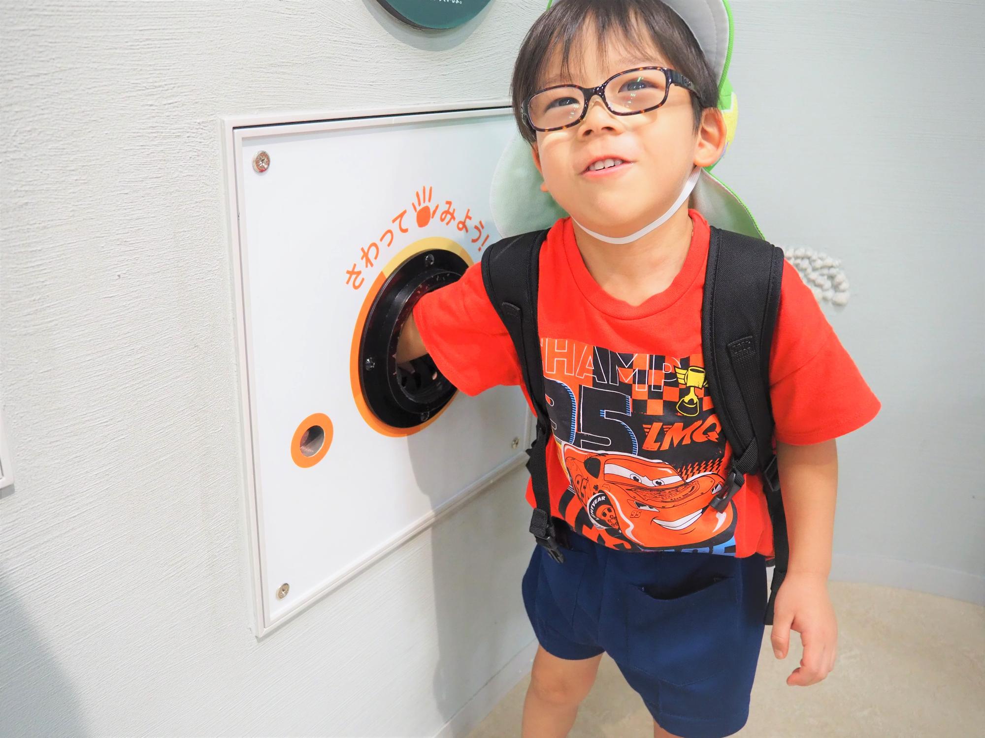 琵琶湖博物館のライブラリーで手探りで何かを触っている子供