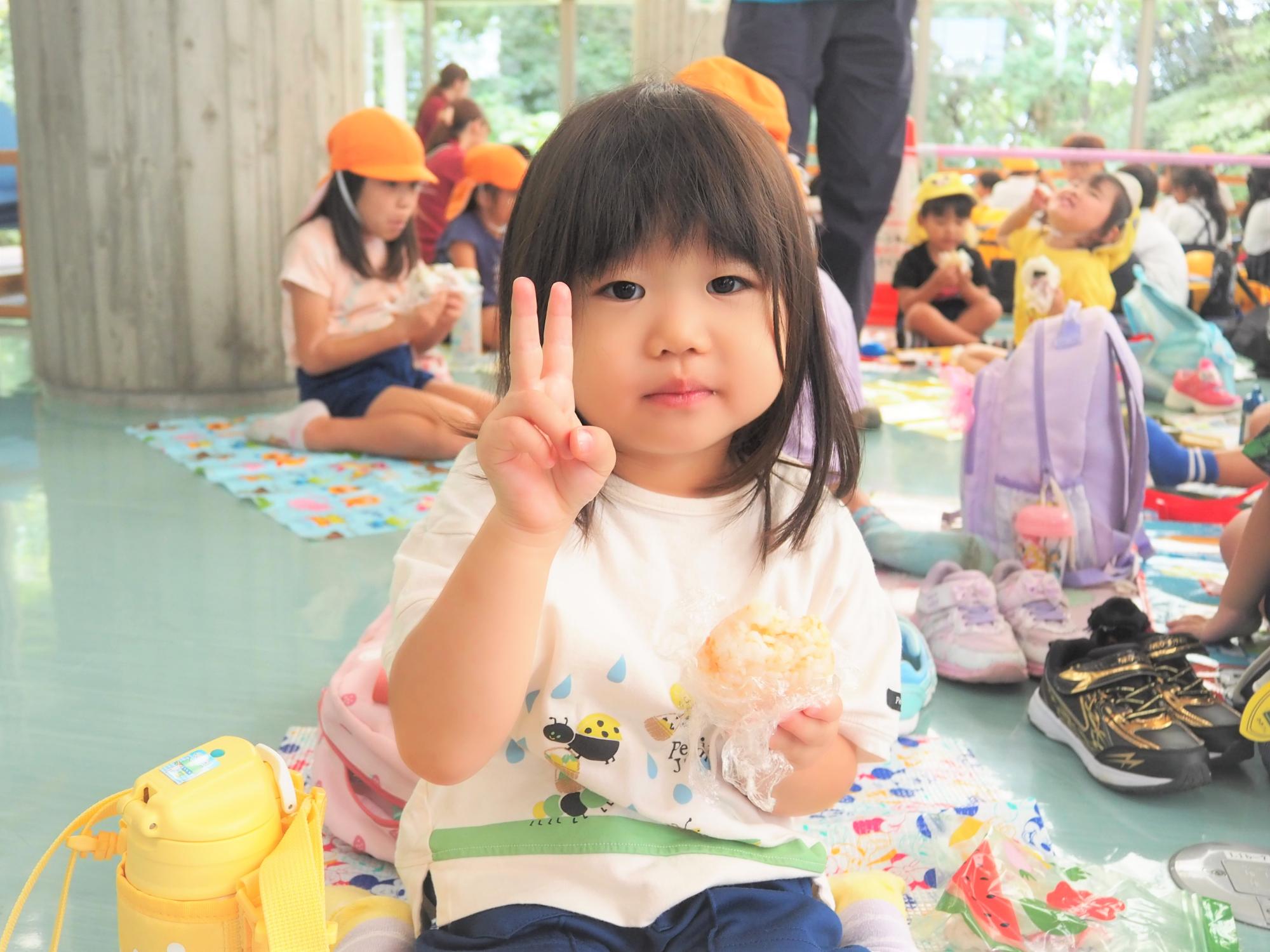 おにぎりの弁当を食べている子供