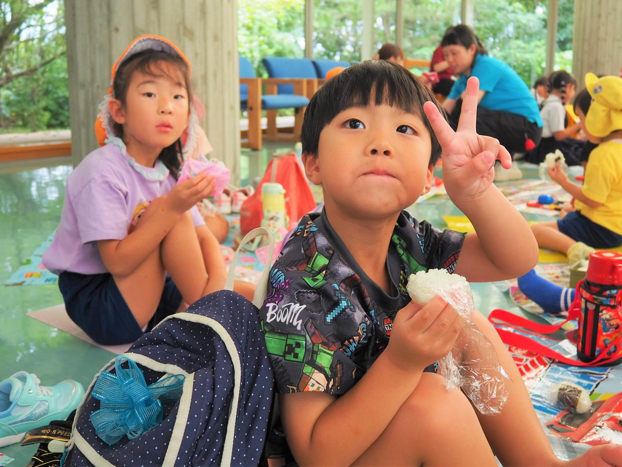 おにぎりの弁当を食べている子供
