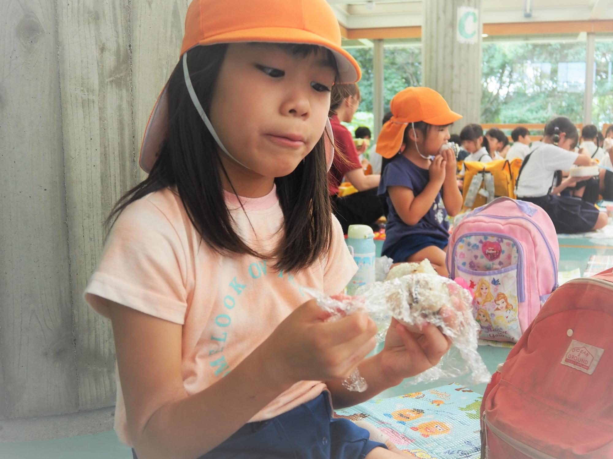 おにぎりの弁当を食べている子供