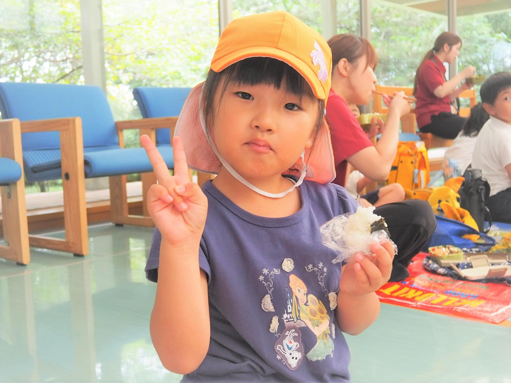 おにぎりの弁当を食べている子供