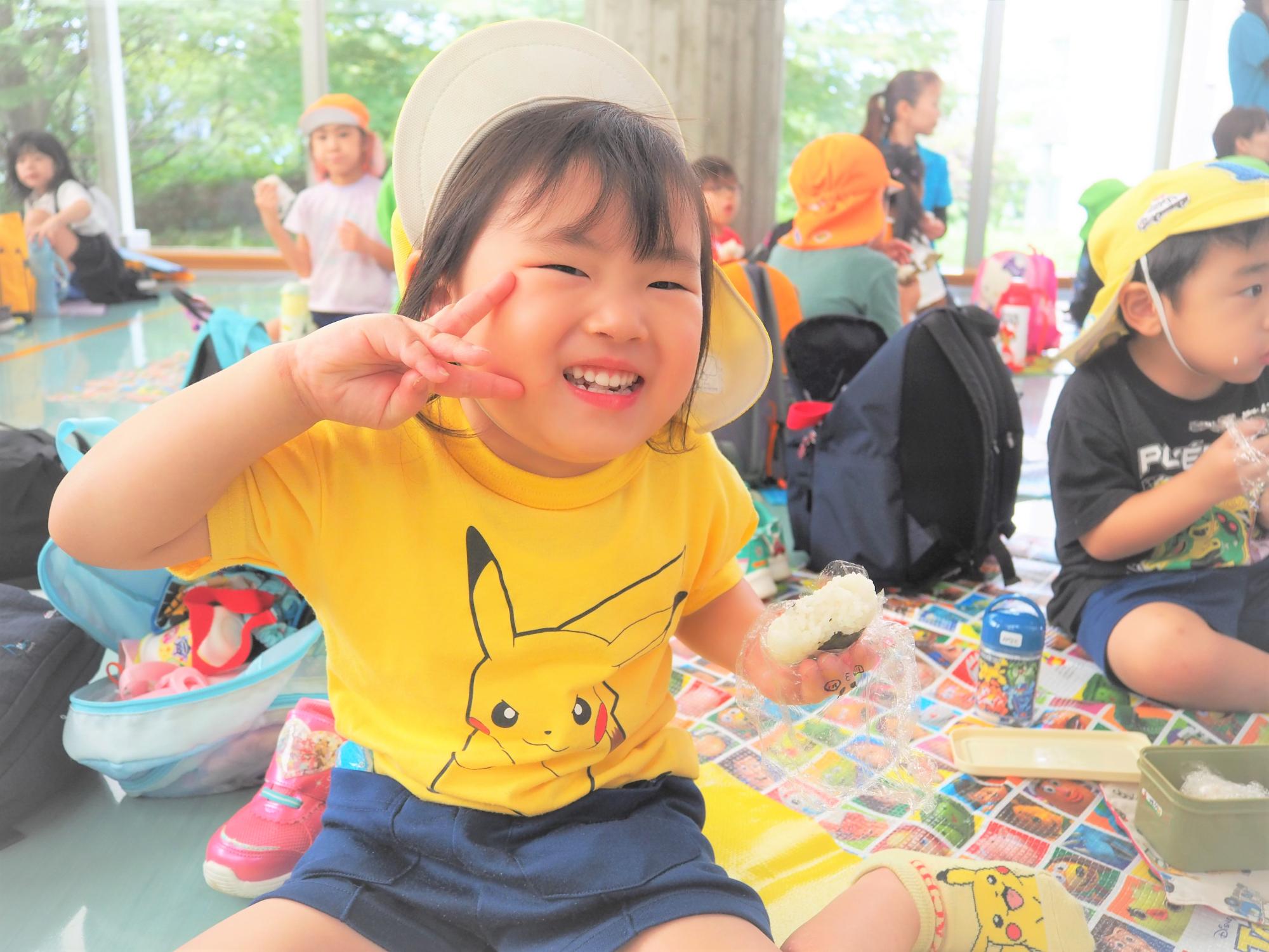 おにぎりの弁当を食べている子供