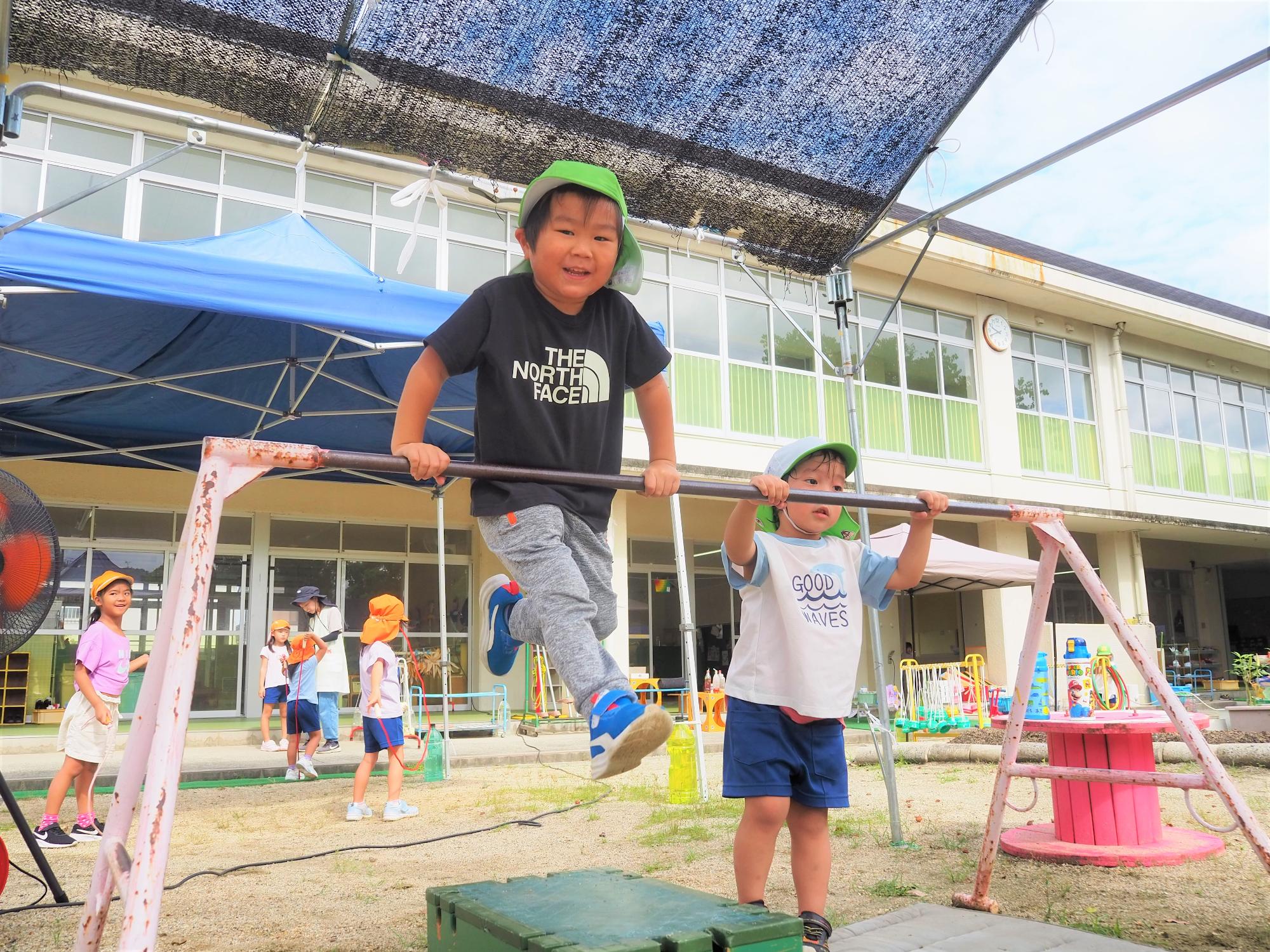鉄棒にとびついている子供