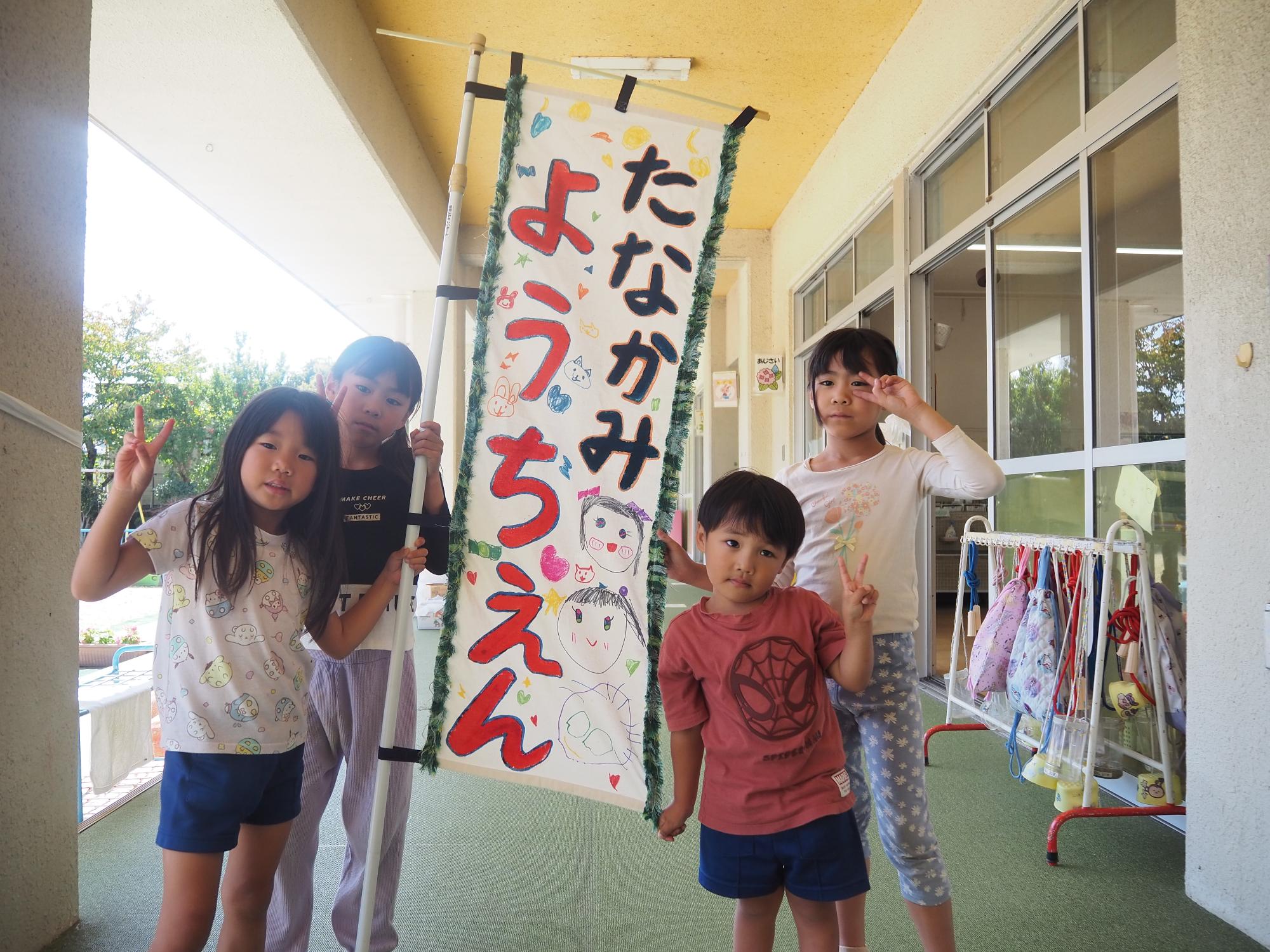 かかし村に掲げる旗を持つ子供