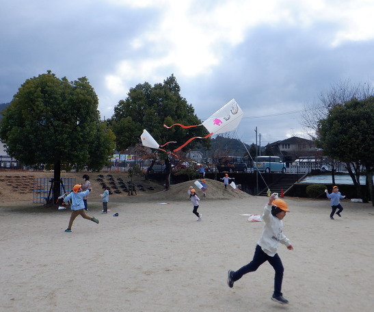 凧揚げを楽しむ5歳児の子どもたちの写真