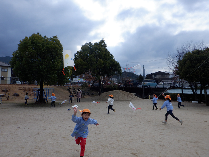 凧揚げで思いっきり走る5歳児の子どもたちの写真