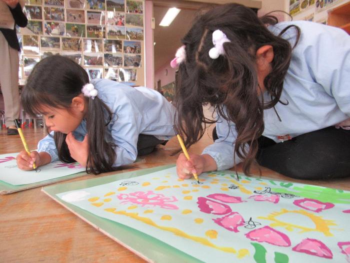 コスモス畑で遊んだ時の絵を描いている5歳児