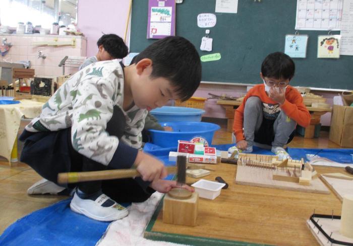かな図値を使って釘打ちをして遊ぶ5歳児