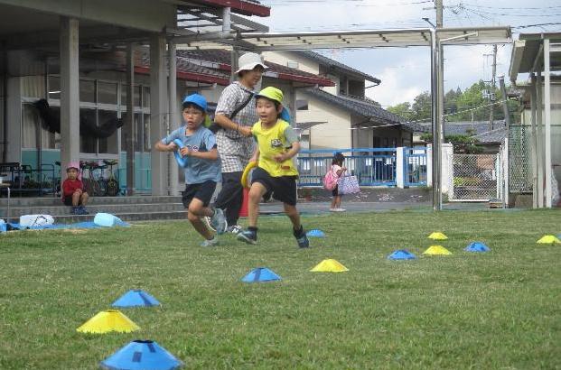 リレーの取組でバトンを受け取り走り出す5歳児