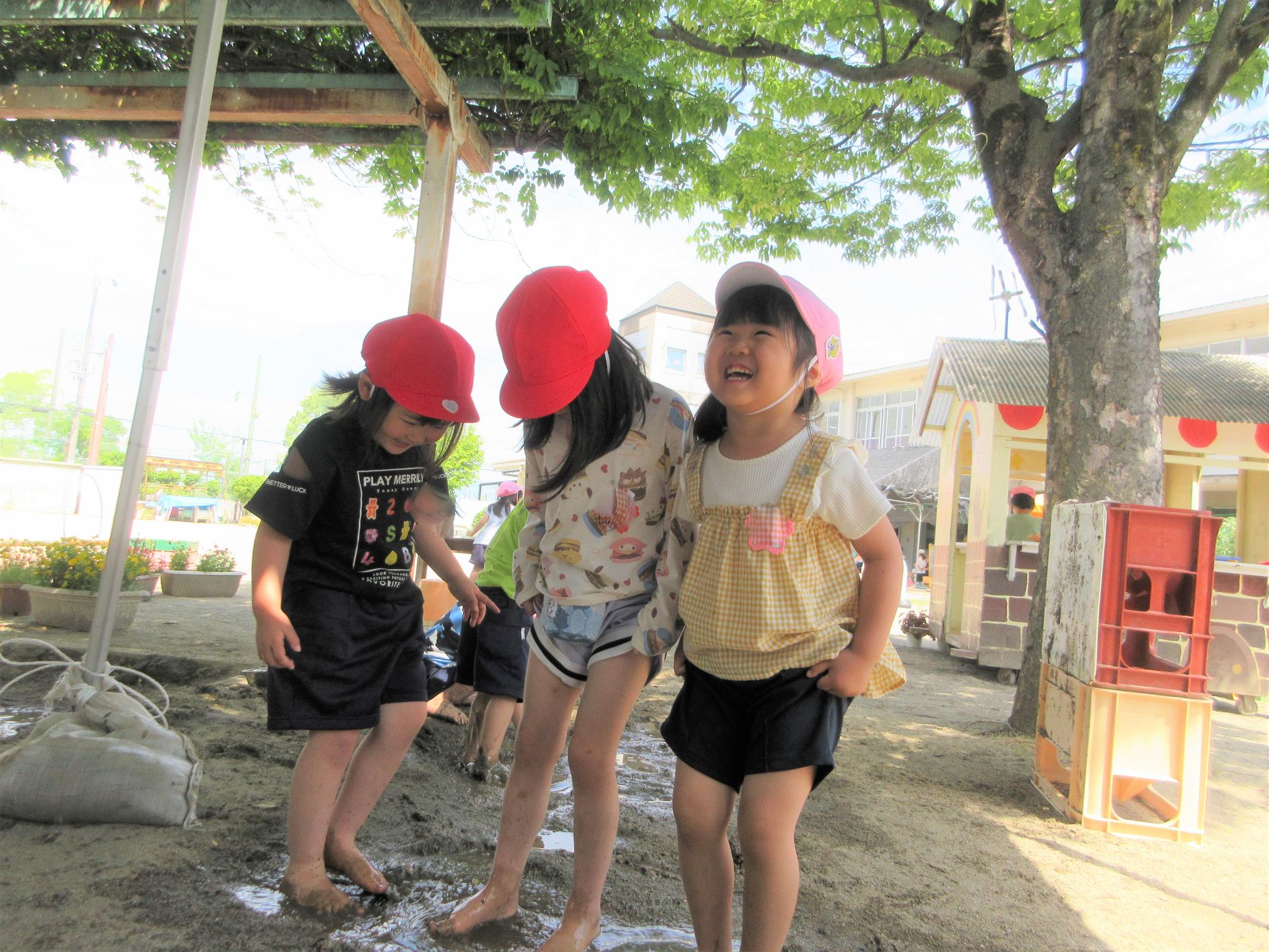 砂場で水遊びをする4歳児の様子