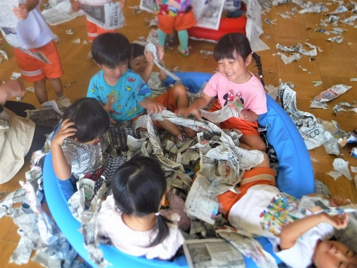 3歳児が新聞紙で遊んでいる様子