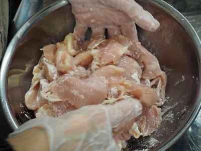 鶏むね肉に薄力粉をまぶす様子