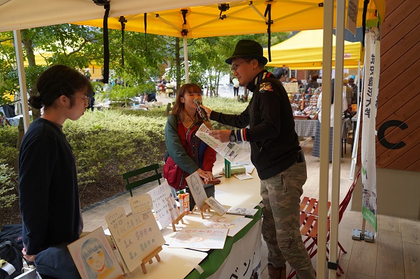サザキヒロシさんがブースでインタビューする様子