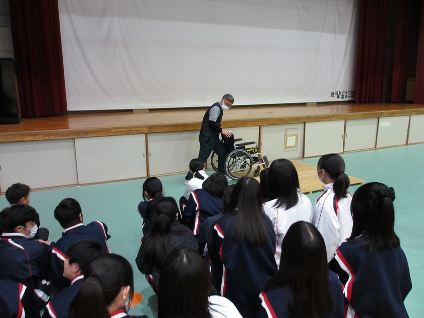 講師から車椅子の操作について説明を受ける生徒