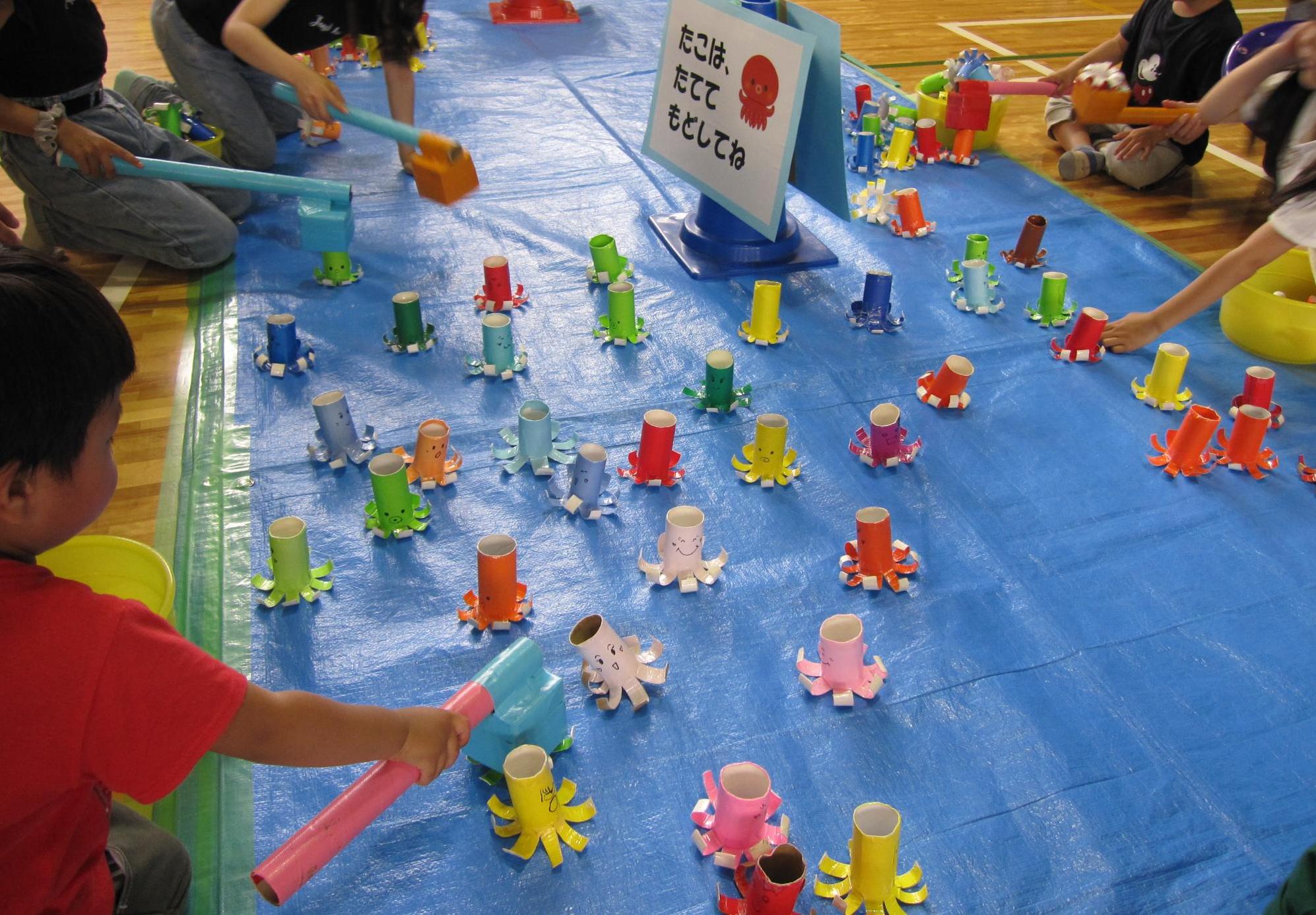 参加団体による催し(子供たちがタコのおもちゃを手作りの棒でキャッチして遊んでいる様子)