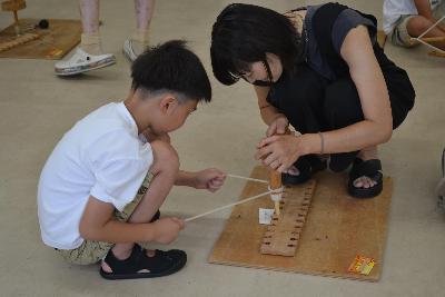 親子でヒモぎり式の火起こしに挑戦している様子